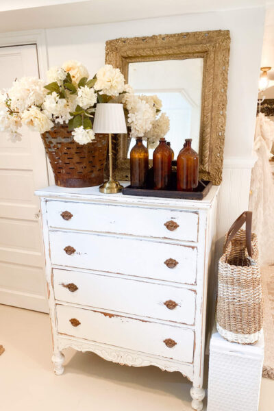 Antique dresser with chippy paint look, vintage mirror and antique amber bottles