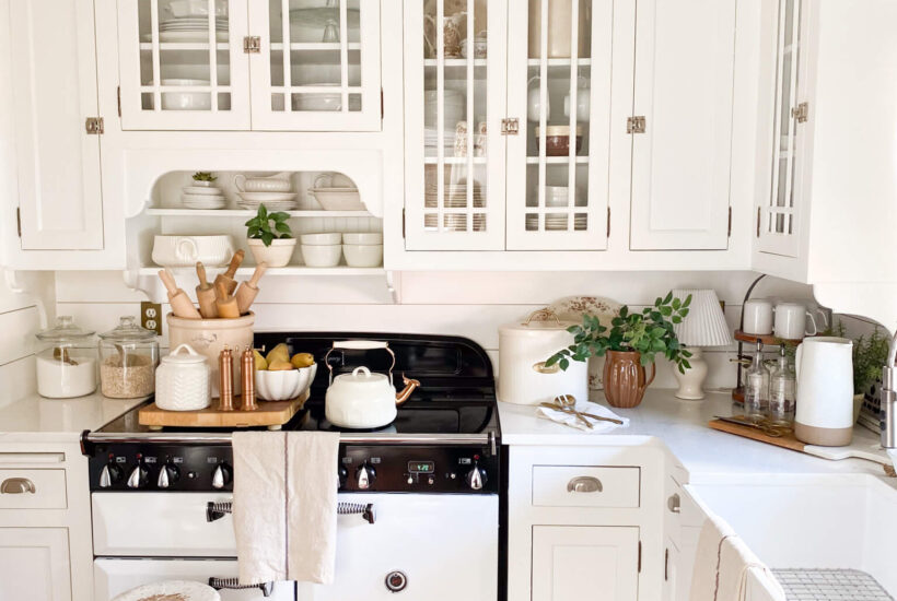 Image of a cottage style kitchen with white cabinets, AGA vintage inspired stove and farm sink