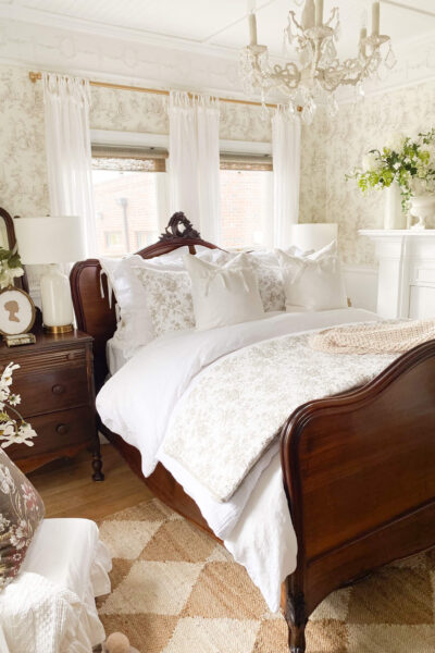 Image of an antique bed with brown and white floral toile quilt