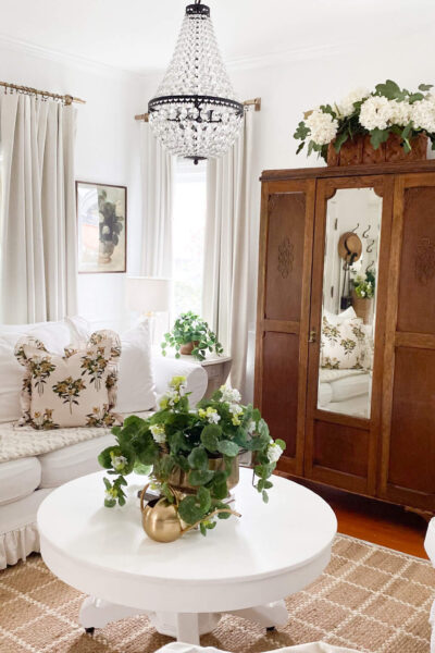 Image of a small cottage living room with slipcovered couch and chandelier