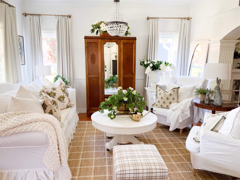Small cottage living room with antiques, chandelier and white furniture