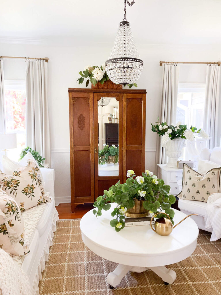 Cottage living room with large chandelier and a vintage round coffee table