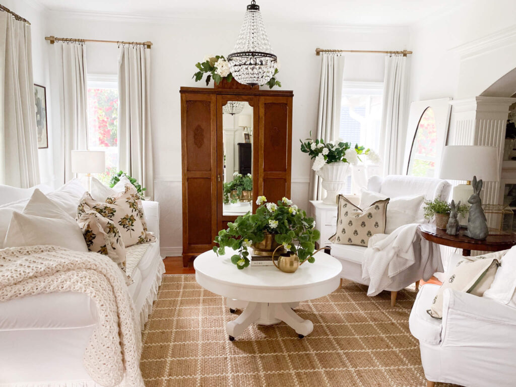Tips for how to decorate a living room with white slipcovered furniture, an antique armoire and large jute rug