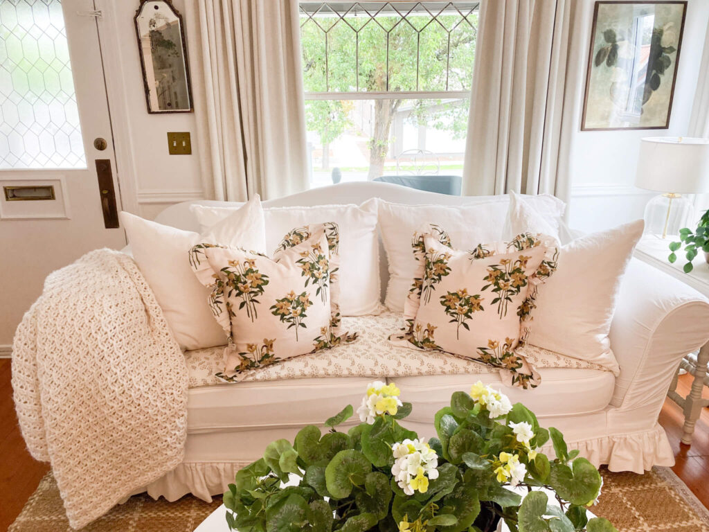 White slipcovered couch and linen curtains for a small cottage living room