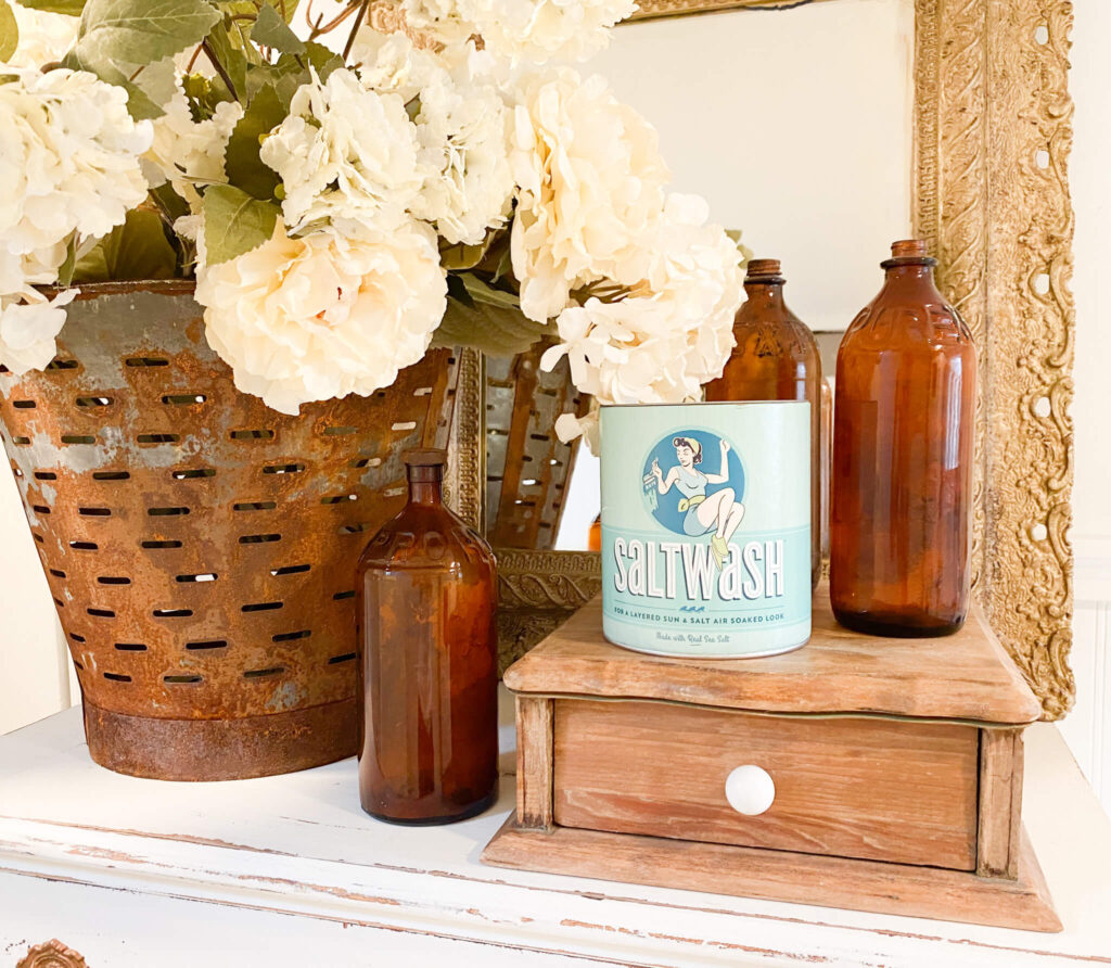 Saltwash product for a distressed furniture finish with Vintage bottles, a rusted olive bucket and spring florals