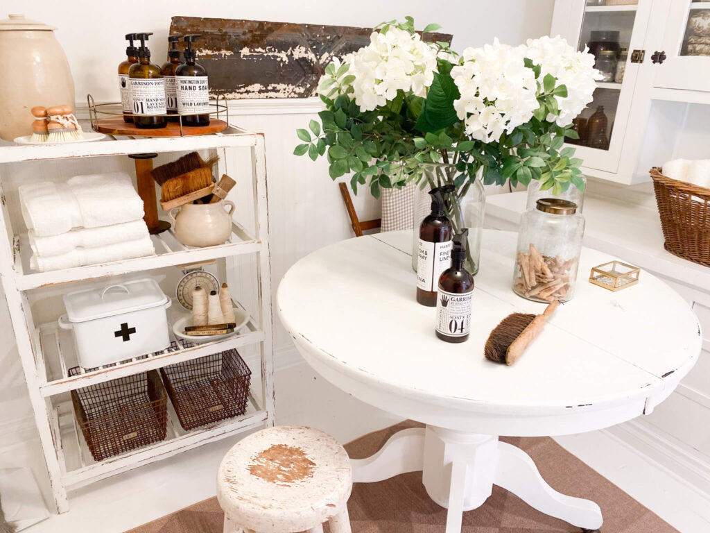 Small cottage laundry area with vintage storage solutions, an old large built-in cupboard and round folding table