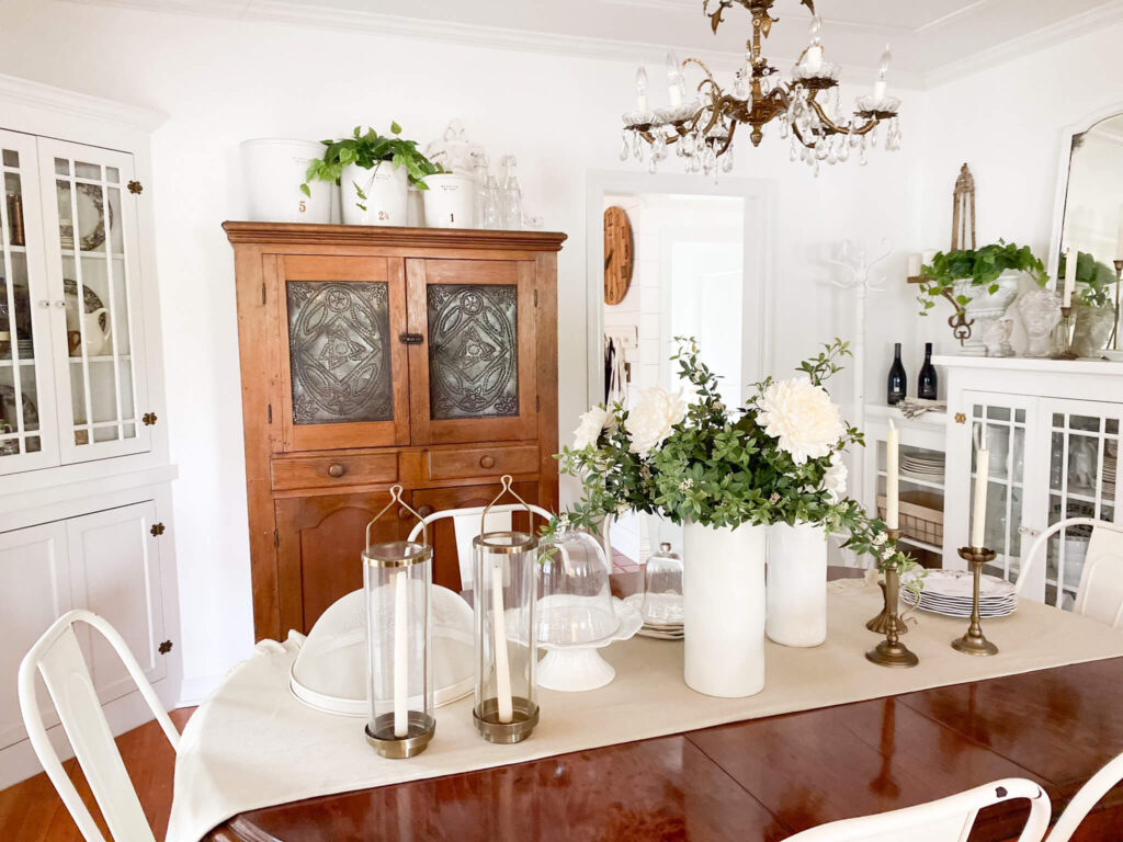Dining room with antique farm table, old pie cupboard and a vintage brass chandelier