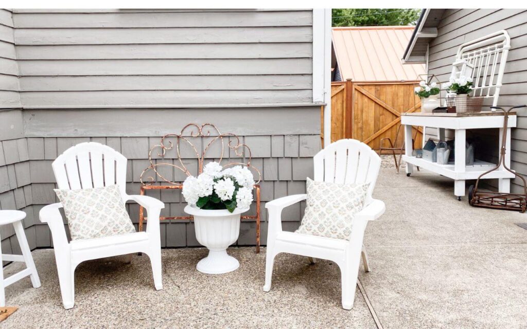 Patio refresh with white Adirondack chairs and DIY floral pots
