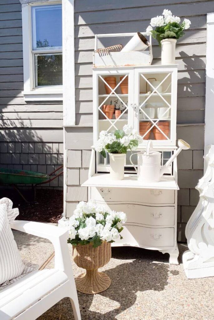 Old white cottage vintage desk used for outdoor DIY potting bench.