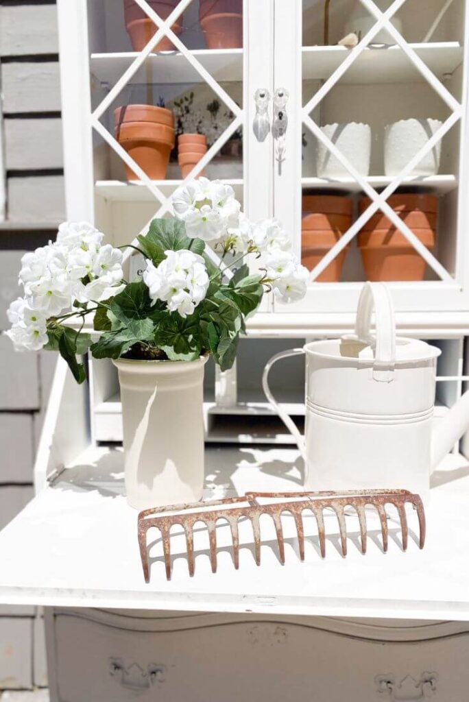 DIY white floral with watering cans, terra cotta pots for a DIY white potting bench