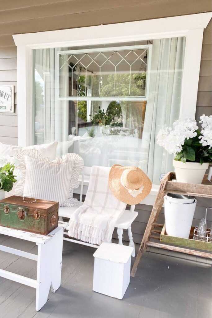 Vintage summer porch with white bench and faux white florals