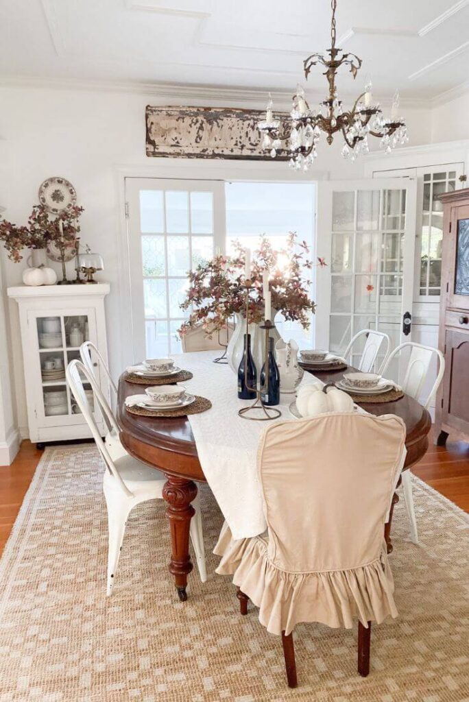 Cozy vibes in a fall dining room with a jute rug, slipcovers and fall stems