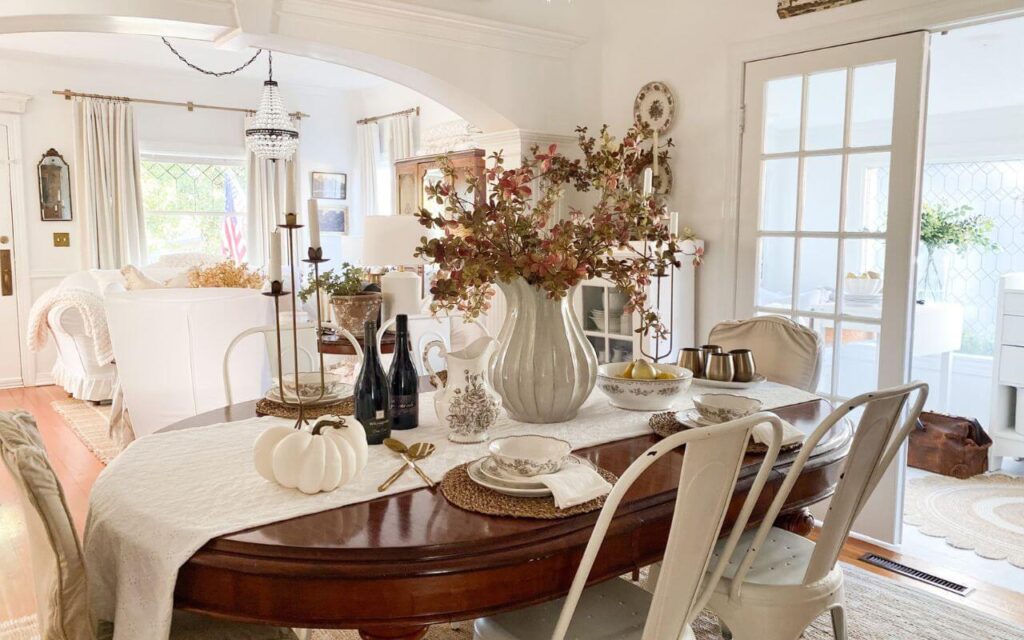 Formal dining room styled for fall with fall stems and brown transferware everyday dishes