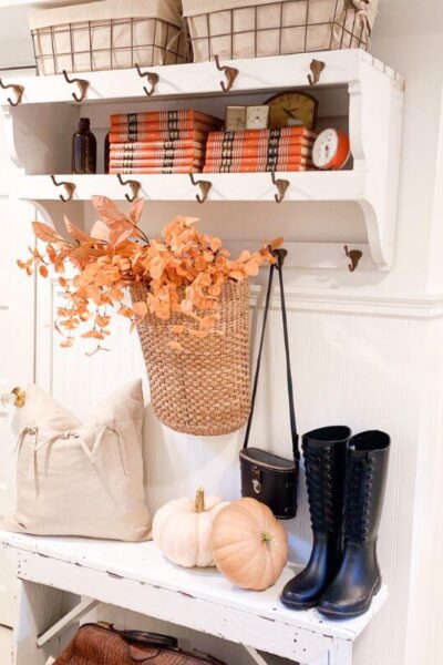 Budget-friendly fall entryway decor featuring antique books, pumpkins, and cozy cottage textures