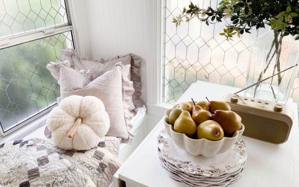 Fall reading nook with pumpkin and ruffled pillows