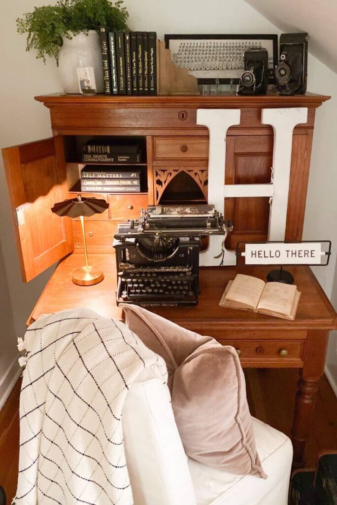 Close-up of desk decor with vintage typewriter, usb lamp and antique books