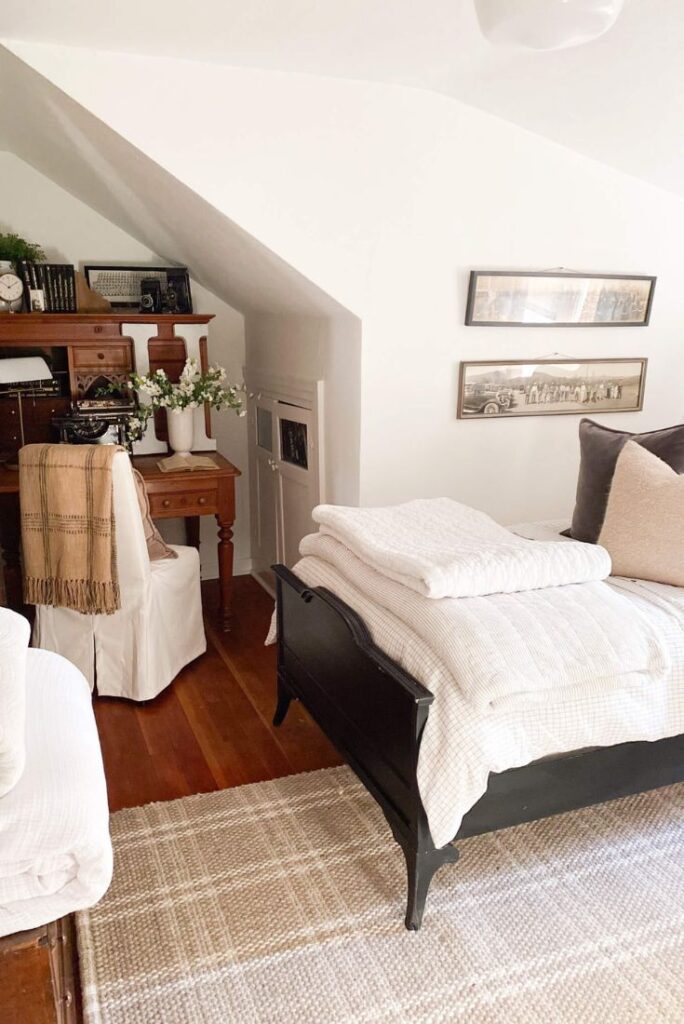 Cottage bedroom with plaid rug and vintage military photo gallery wall
