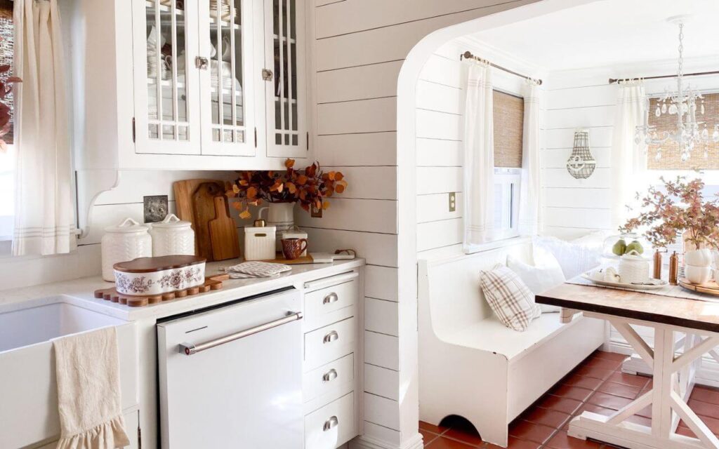 Simple fall kitchen decor with white pumpkins and copper accents and white vintage style cabinets