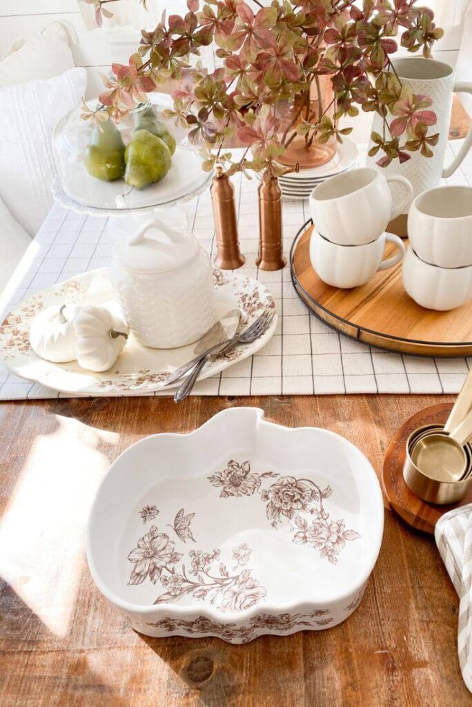 Detail shot of transferware plates and fall leaves on a small kitchen table
