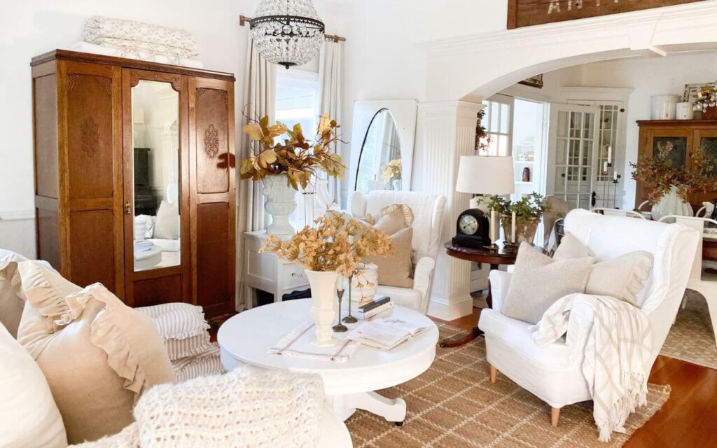 Cozy cottage living room with candelabras, textured pillows, and layered linens.