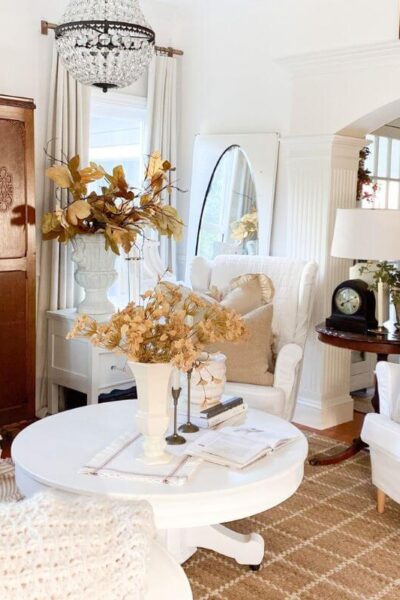Cozy cottage living room with candelabras, textured pillows, and layered linens.