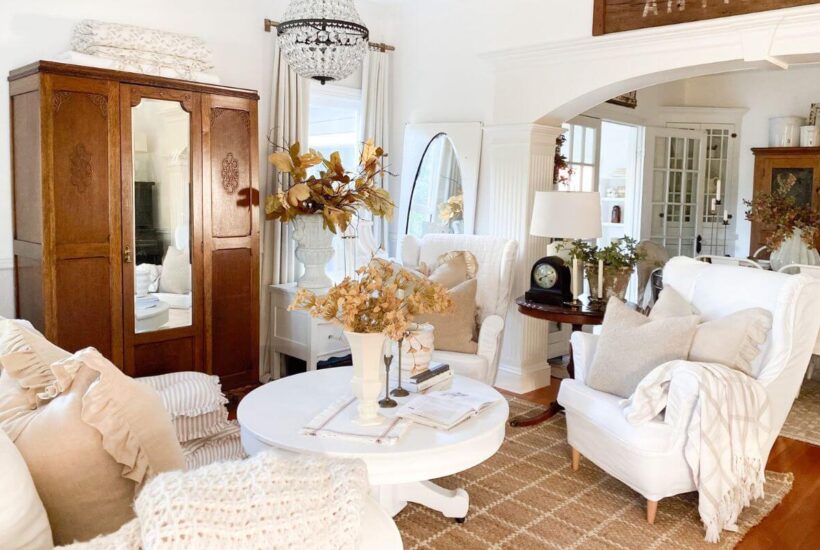 Cozy cottage living room with candelabras, textured pillows, and layered linens.
