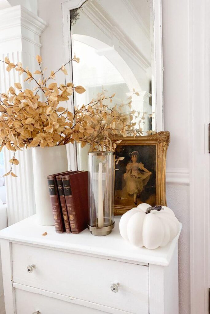 Fall stems, faux white pumpkin, antique books and an antique dresser for a small entryway