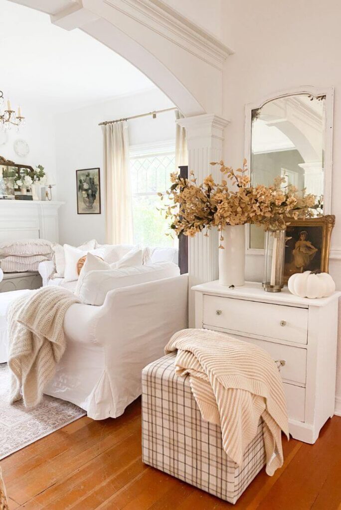 Simple fall entryway ideas featuring autumn stems, gold frame, and plaid ottoman