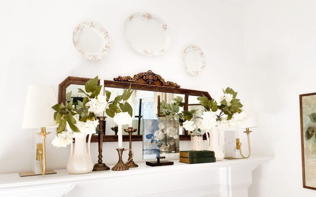 Stack of vintage books with small vases and transferware dish display