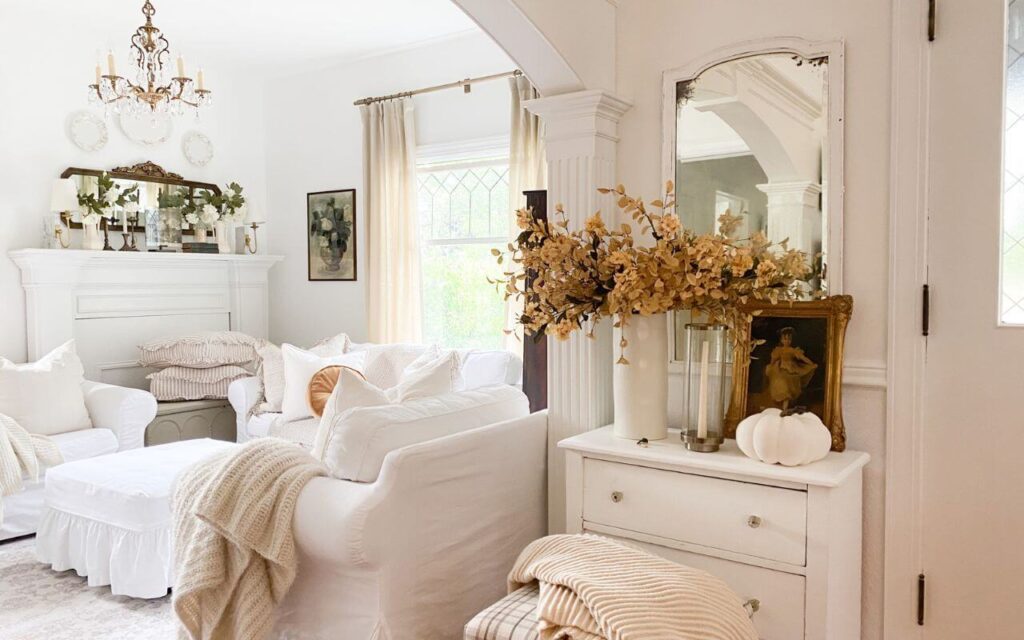 Neutral fall entryway styled with warm autumn branches and antique accents