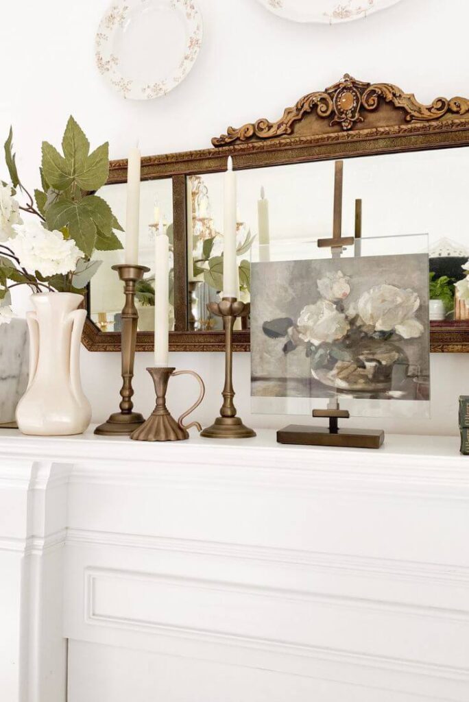 Vintage style floral print in display easel with vintage mirror and layered decor pieces