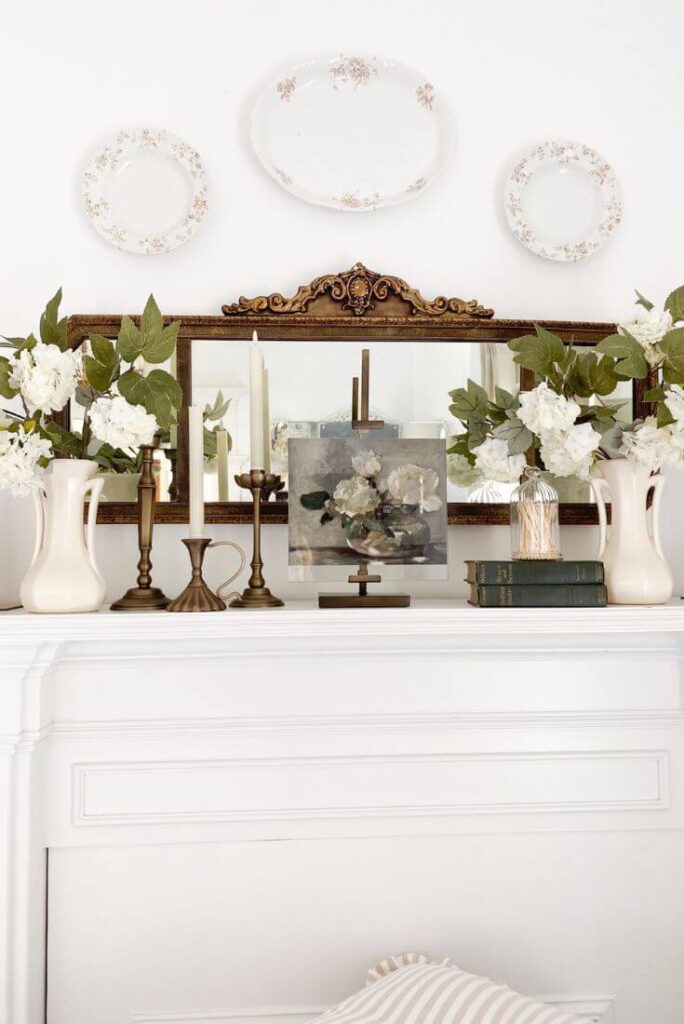 Close-up of vintage books and transferware dishes layered on a cottage-style mantel