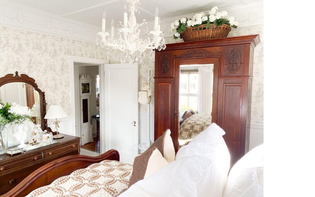 Cozy winter bedroom refresh with antique armoire and vintage chandelier