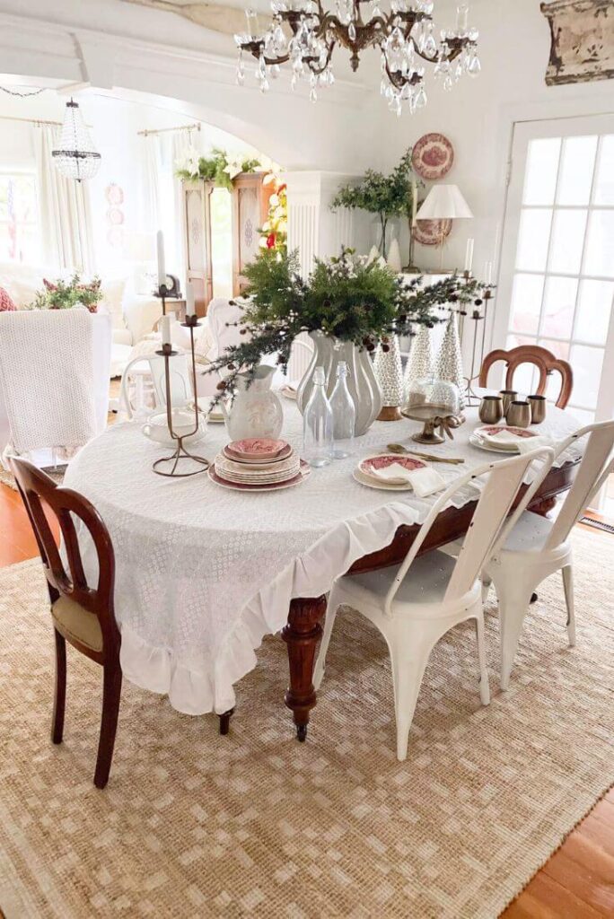 Dining room styled for Christmas with red vintage dishes and anchored with a patterned jute rug