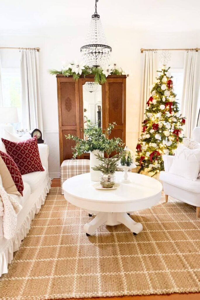 Living room with jute rug styled for Christmas with red accents for simple ways to style jute rugs.