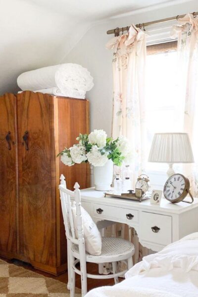 Bright cottage guest room with floral curtains and white bedding