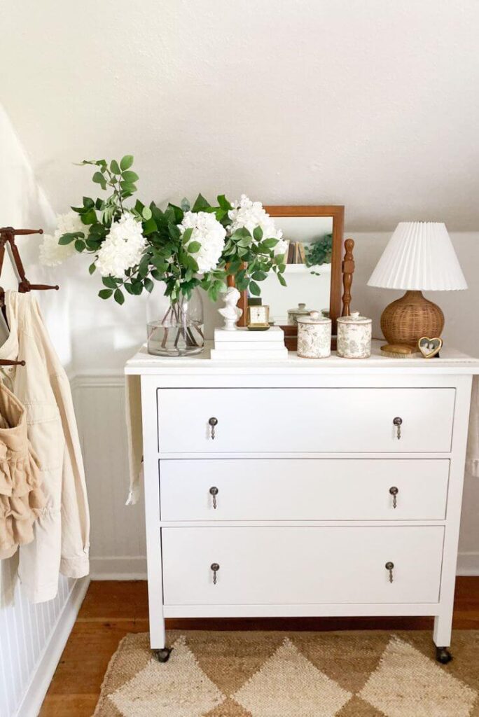 Front view of small white dress and antique mirror in a cottage guest bedroom