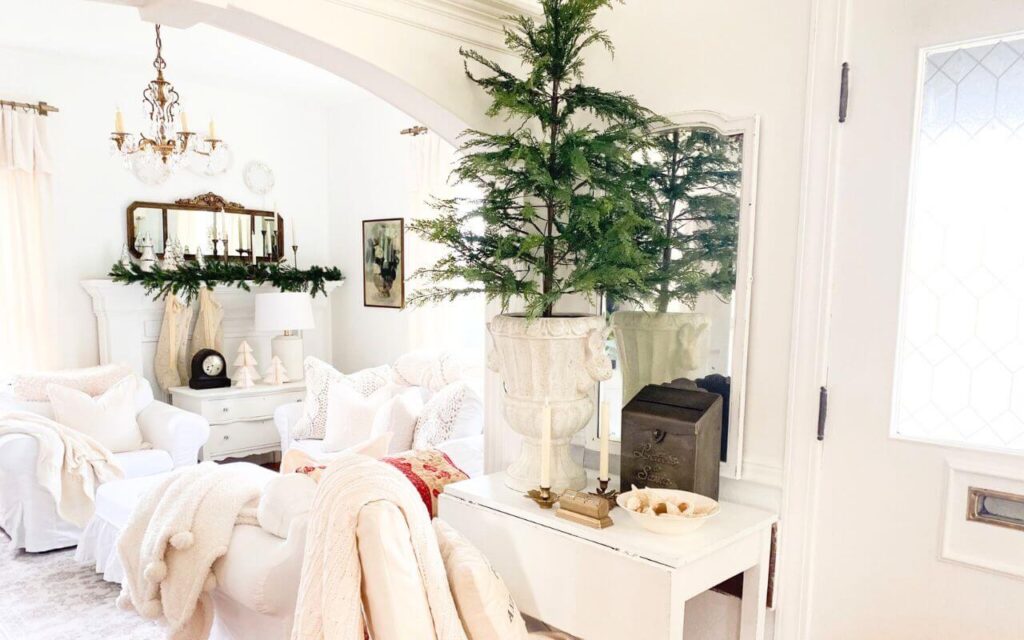 Wide-angle view of the cottage style Christmas entryway leading into the living room with warm, neutral decor