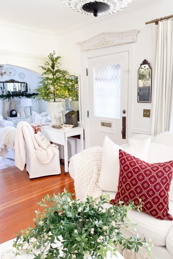 Classic red pillows on a white couch for a neutral Christmas look.