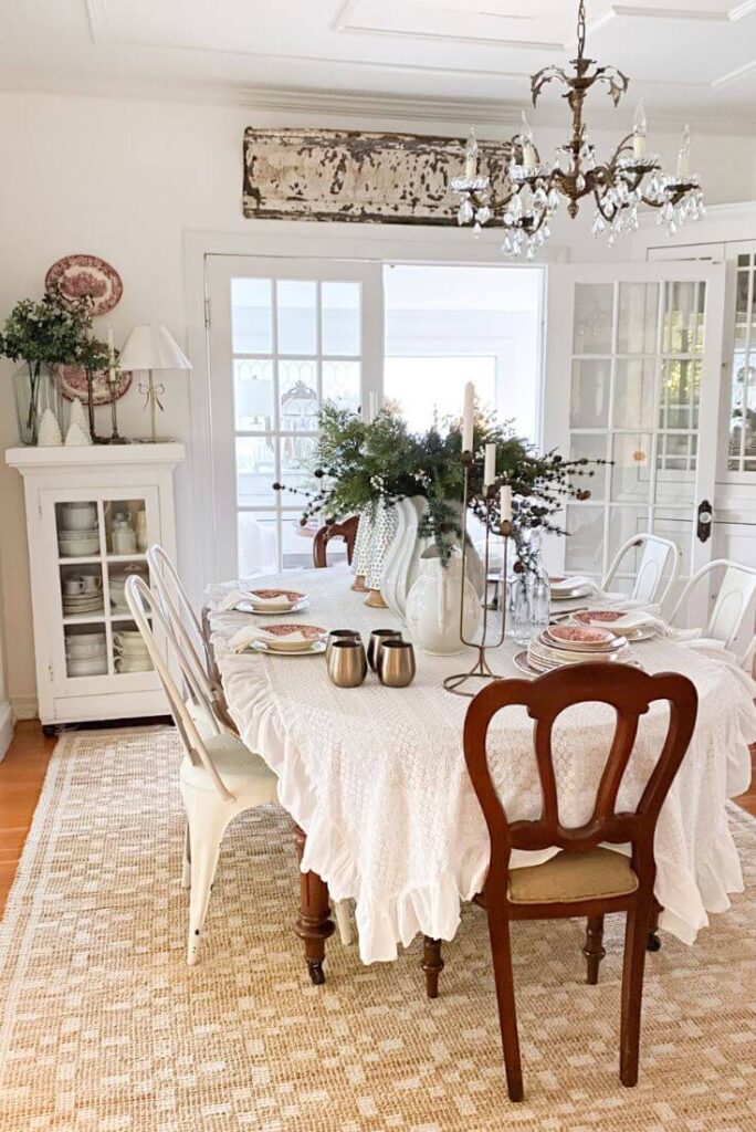 Christmas dining room table styling with vintage red transferware, brass details, and faux greenery centerpiece