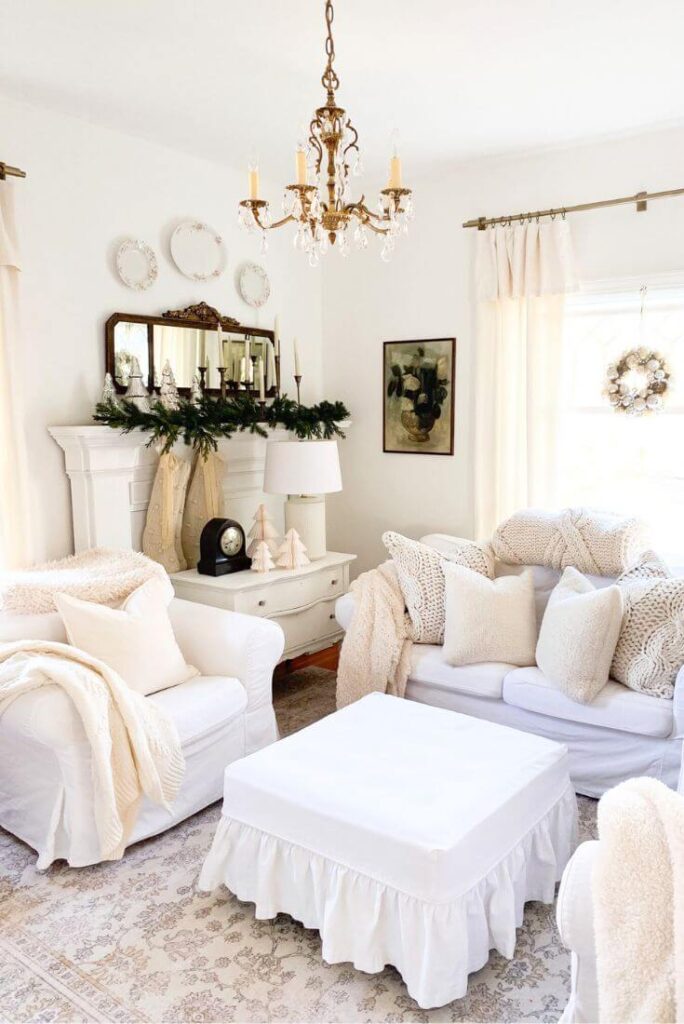 Cozy Christmas mantel scene with soft neutral décor, mercury glass trees, and layered greenery for a simple cottage-inspired look.