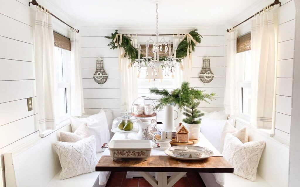 Cozy Christmas kitchen nook featuring Santa mugs, greenery, and dishes.