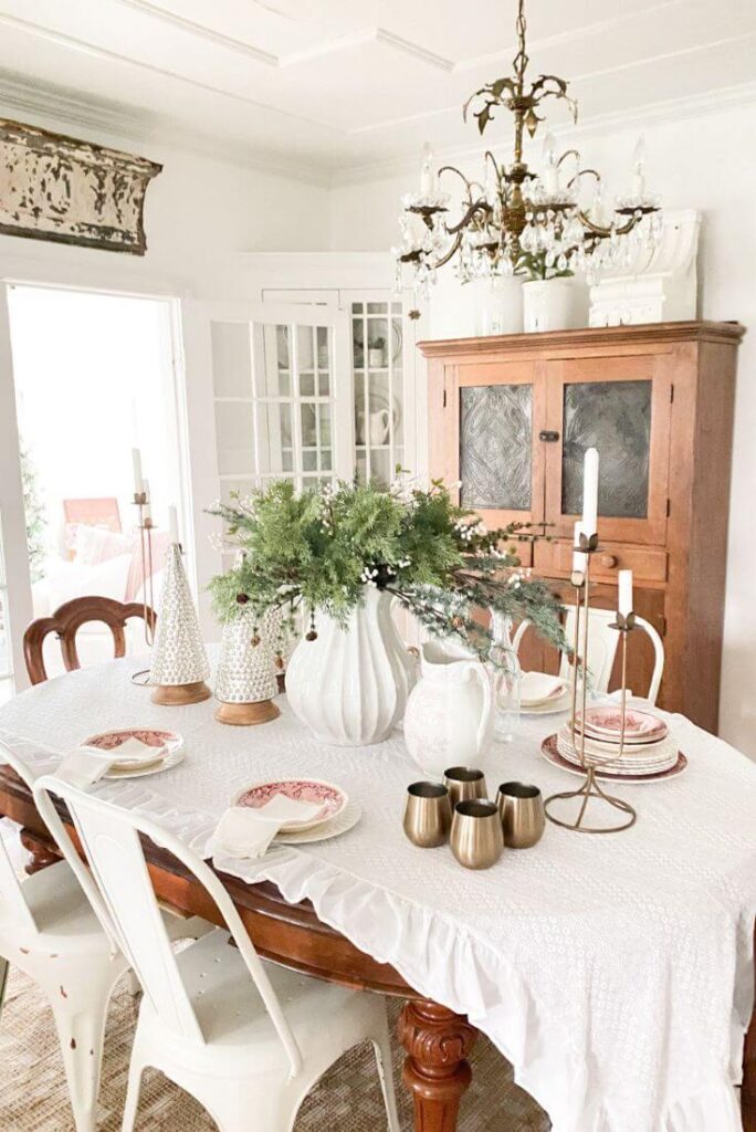 Simple Christmas dining room decor featuring red transferware, mercury glass trees, and a relaxed cottage-style table