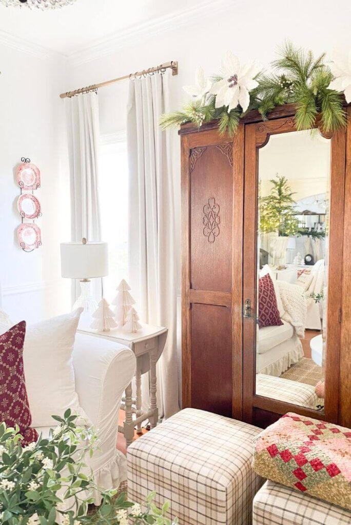 Cottage style, neutral living room with Christmas quilts and pillows with antique armoire.
