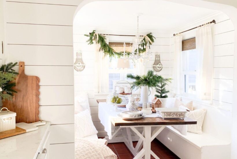 Cozy Christmas kitchen nook with transferware dishes, garland, and greenery.