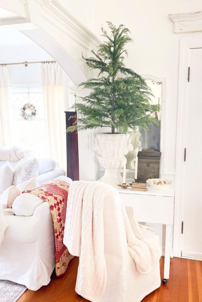 Drop-leaf table decorated with greenery, brass accents, and simple seasonal pieces for a cozy holiday welcome.