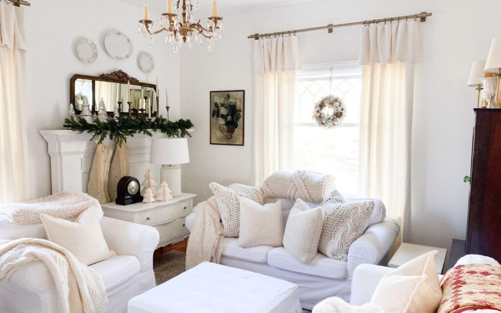 White cozy living room with slipcovered couch and chairs style for Christmas with gold accents and faux greenery