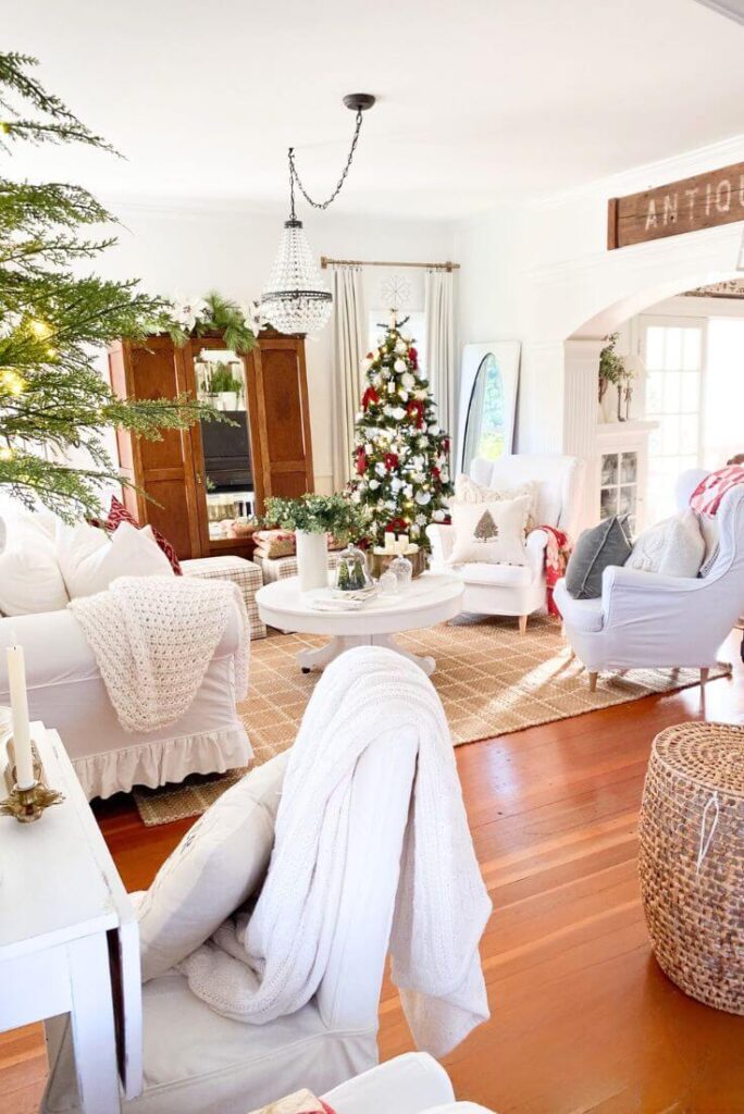 Living room styled with antique furnishings, layered textiles, and subtle red holiday touches