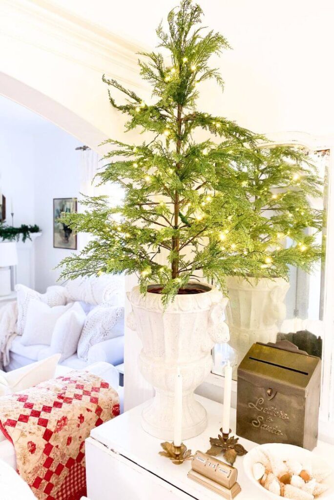 Antique mirror and small table styled with classic holiday pieces and cozy cottage Christmas decor.