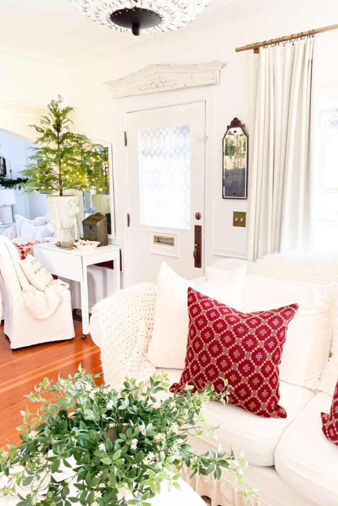Christmas small entryway with prelit tree and pop of red with classic Christmas pillow